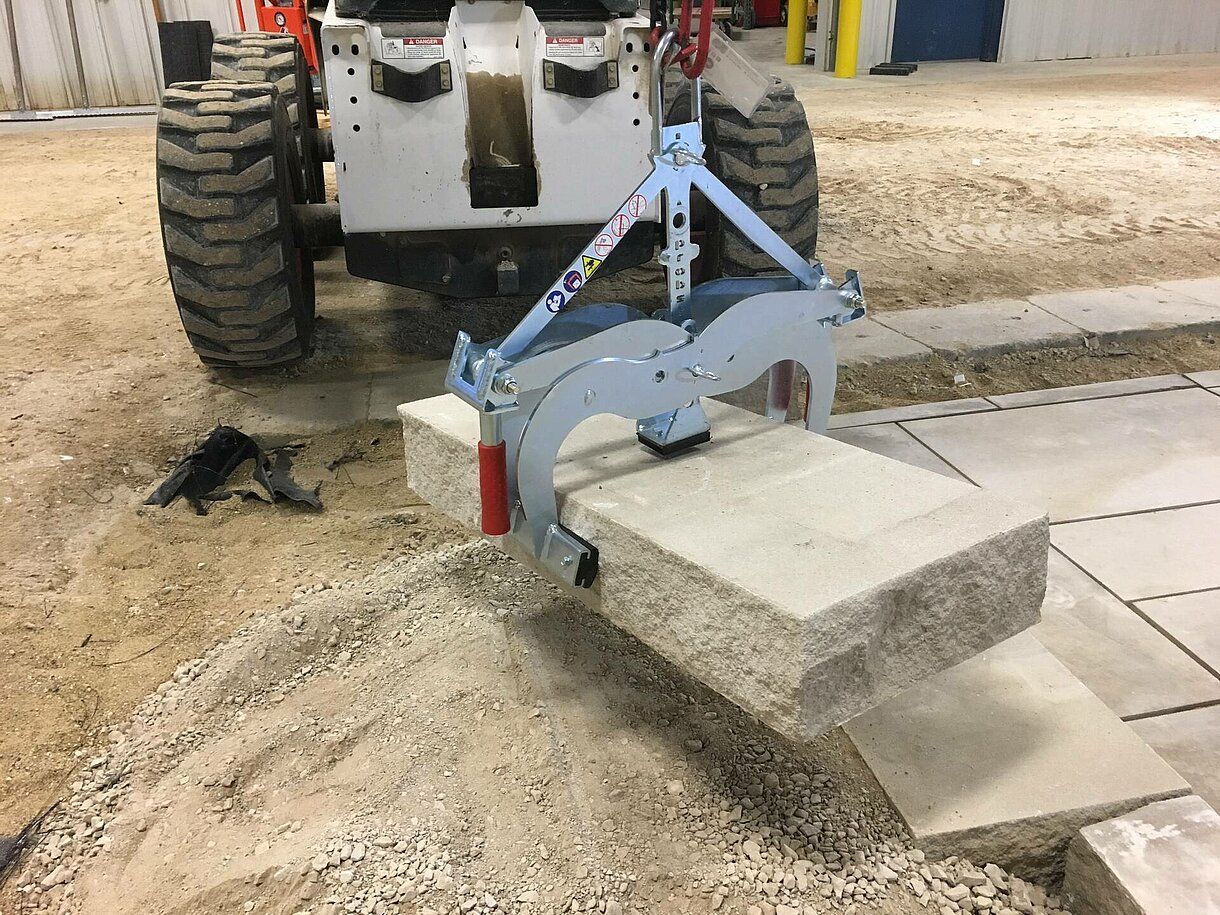 Weingärtner Baumaschinen – Rabattengreifer Probst transportiert Baumaterial über dem Boden