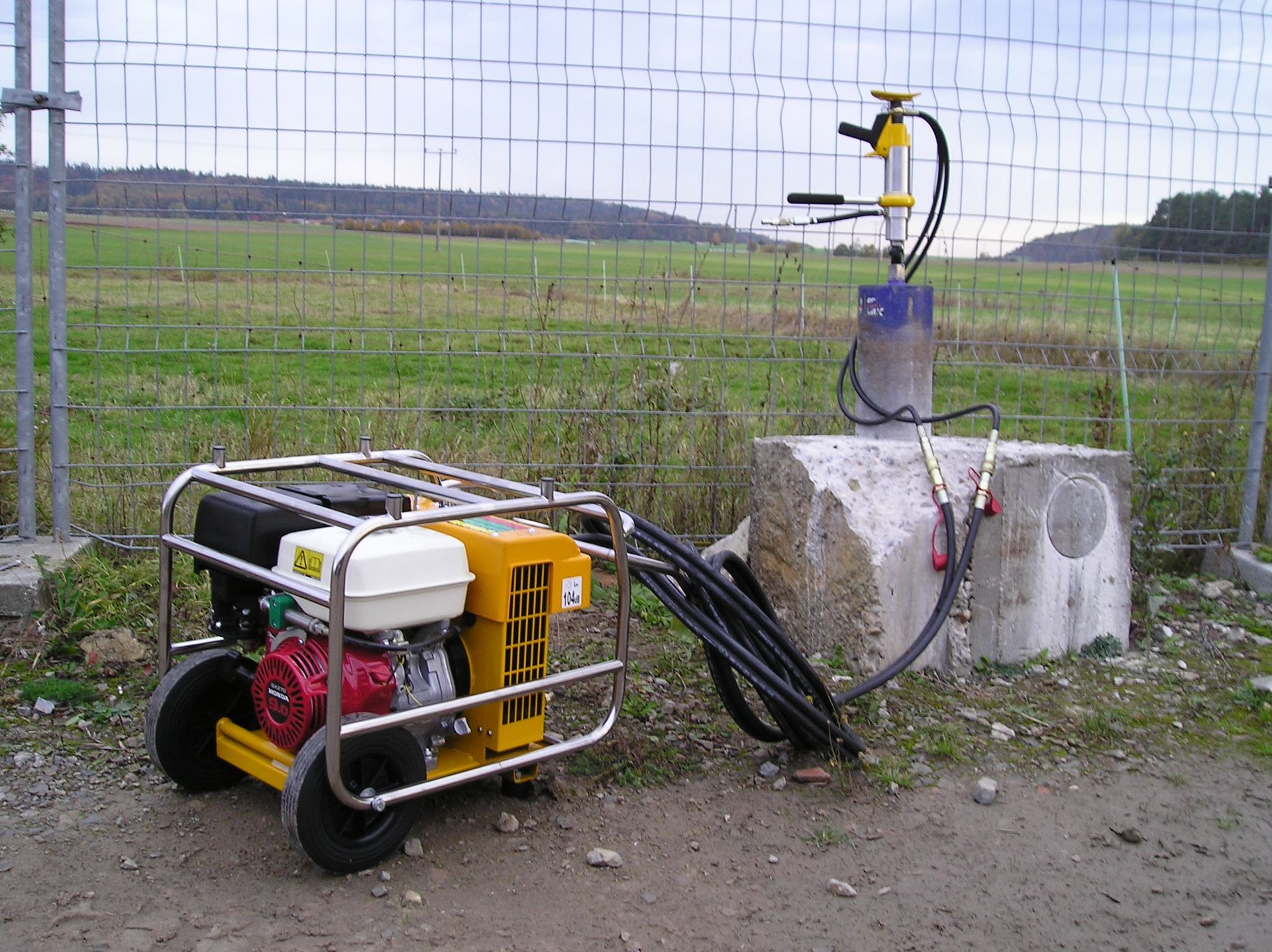 Weingärtner Baumaschinen – Hydraulikstation an einem Bauzaun