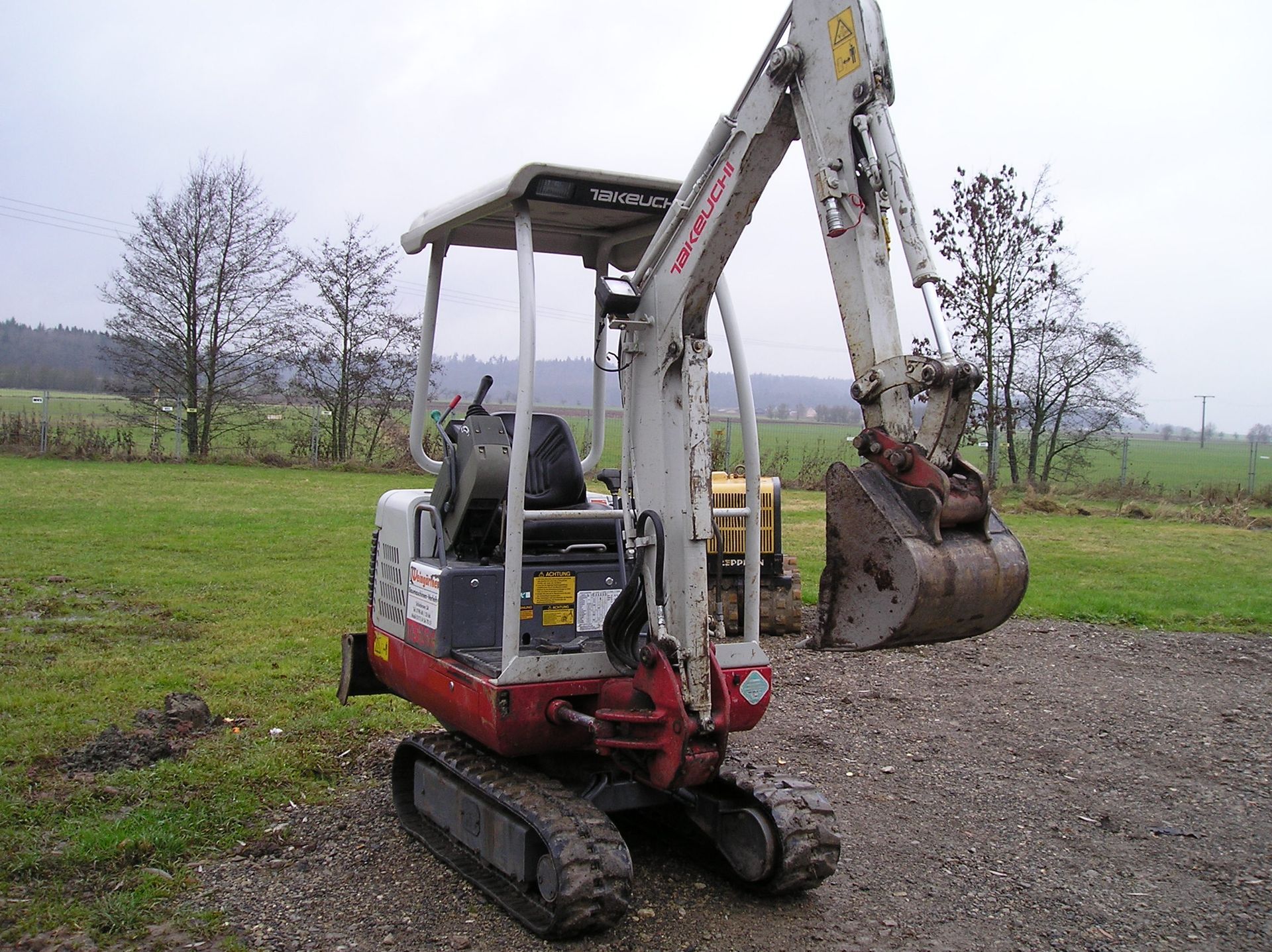 Weingärtner Baumaschinen – weißer Kompaktbagger mit Schaufel