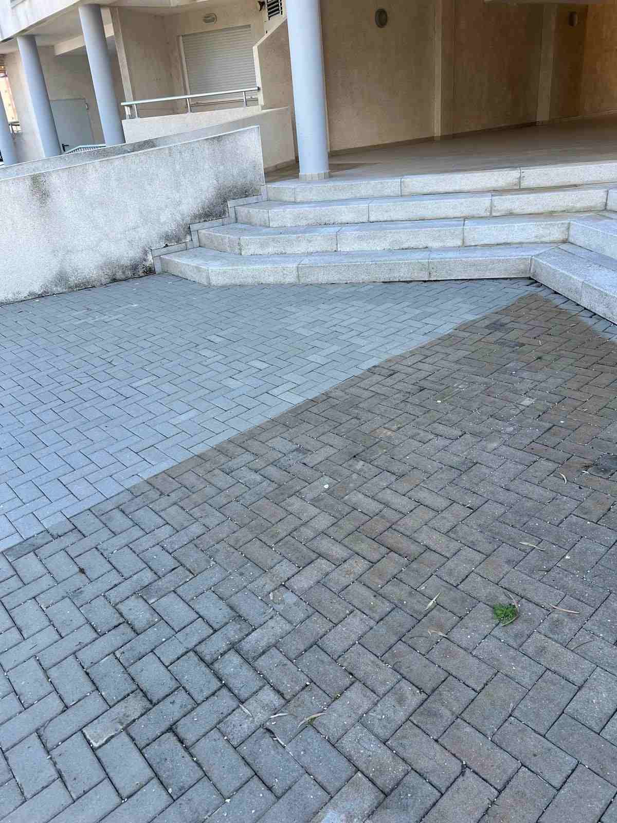 Patio exterior embaldosado con escalones que conducen a la entrada cubierta de un edificio