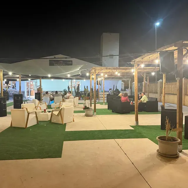 Una gran zona al aire libre con muchas sillas y mesas por la noche.