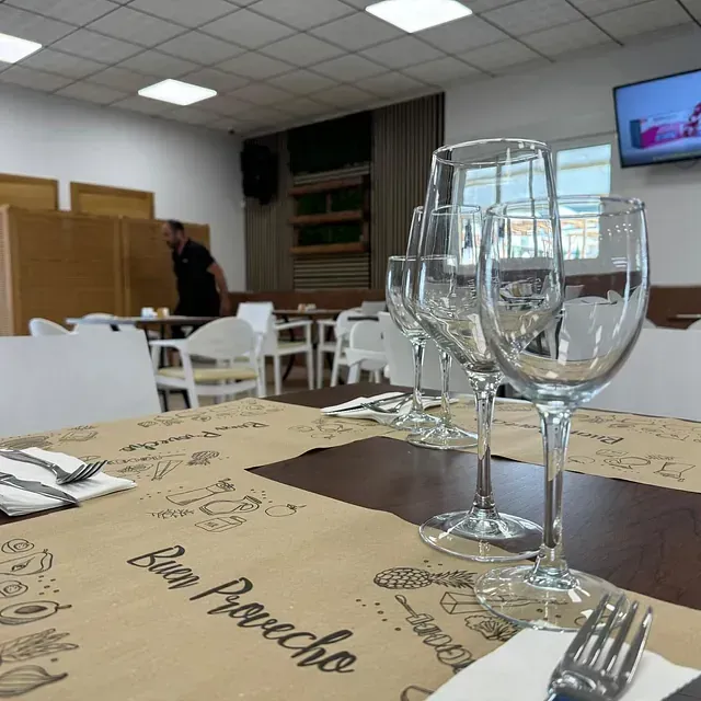 Copas de vino sobre una mesa con un mantel individual que dice 