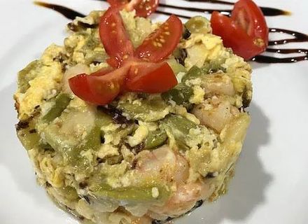 Un primer plano de un plato de comida con tomates encima.