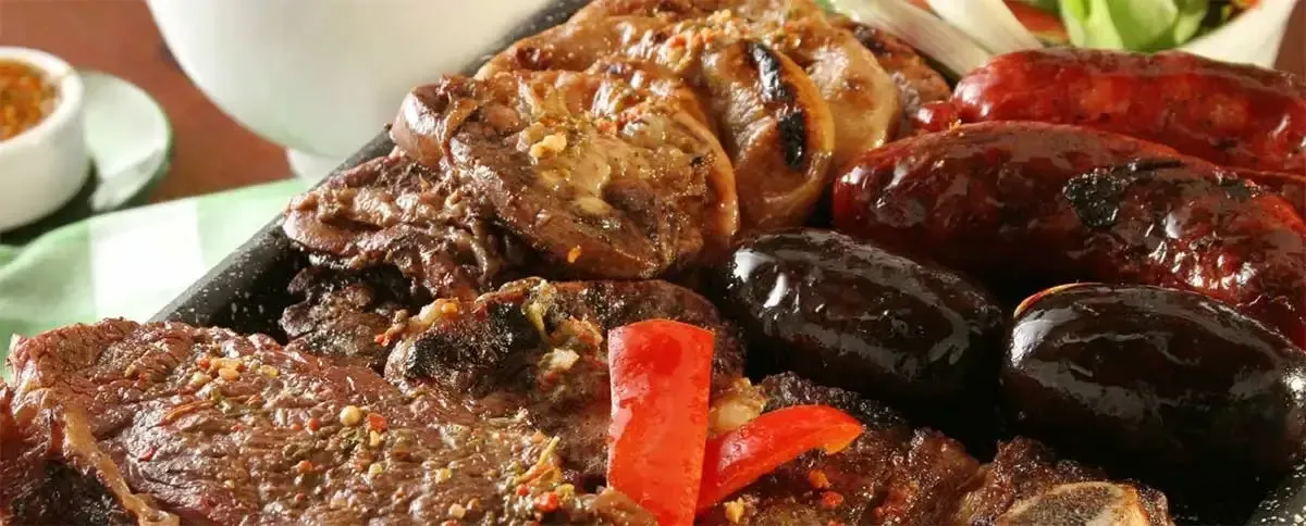 Un primer plano de un plato de carne y verduras sobre una mesa.