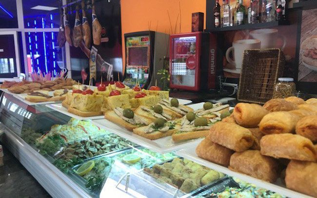 Una vitrina llena de mucha comida en un restaurante.