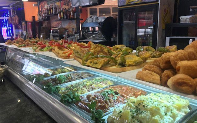 Una vitrina llena de mucha comida en un restaurante.