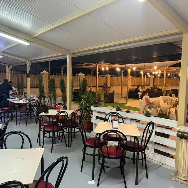 Un restaurante con mesas y sillas bajo un dosel.