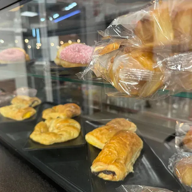 Una vitrina llena de una variedad de pasteles y donas.