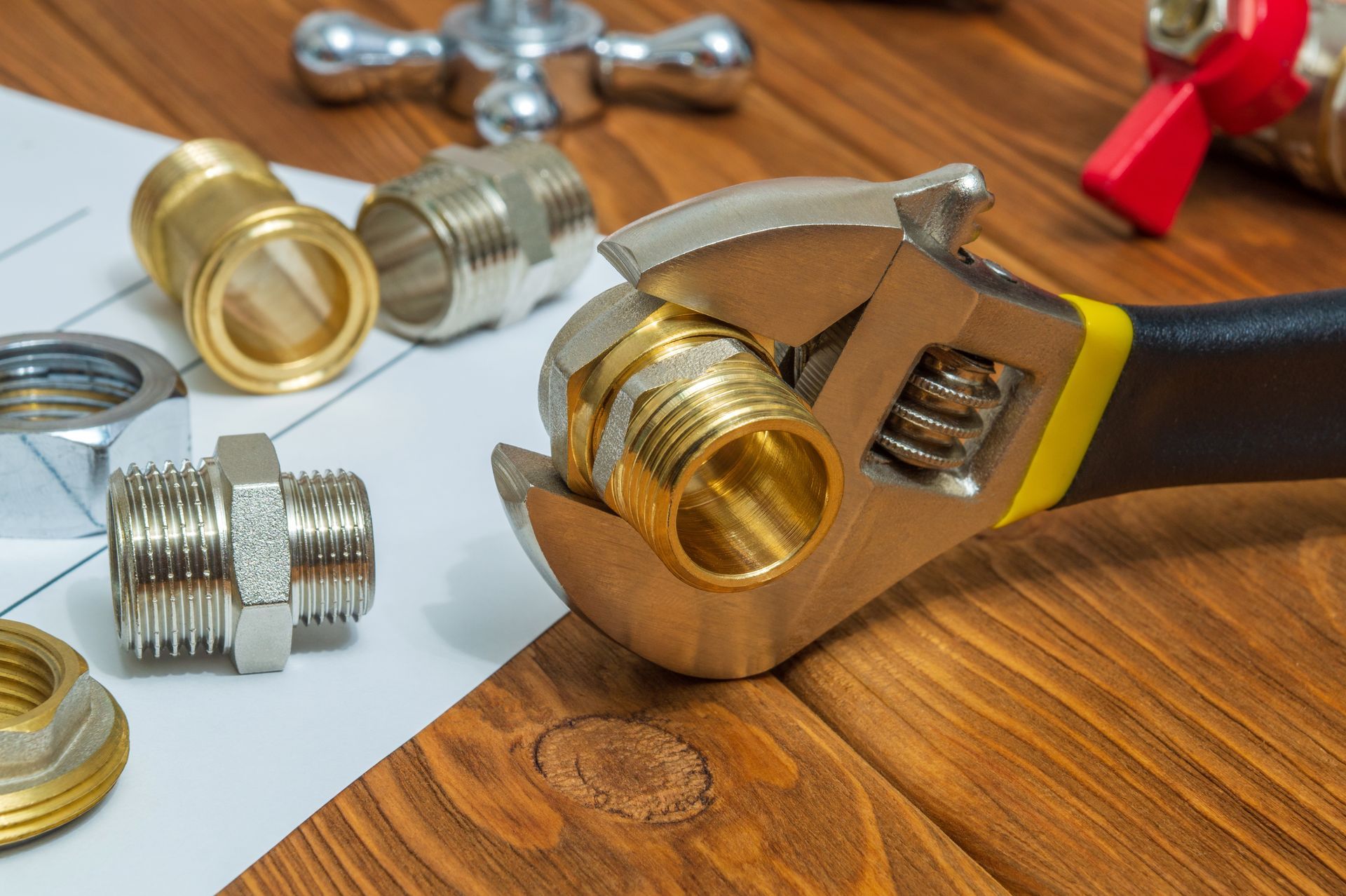 Clé anglaise et plusieurs écrous de plomberie