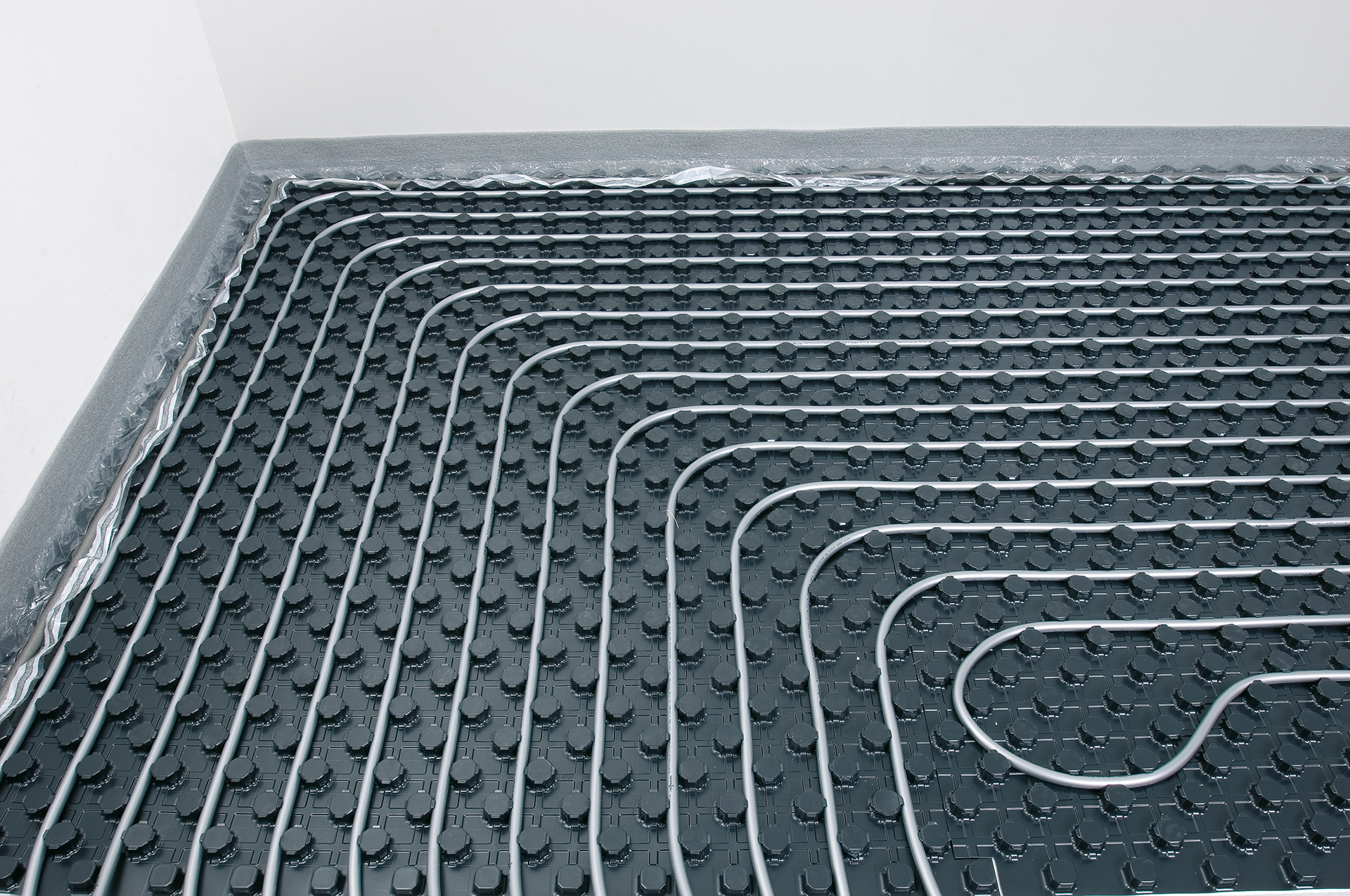 Réseau de tuyaux qui constituent un plancher chauffant et qui recouvrent le sol d'une pièce