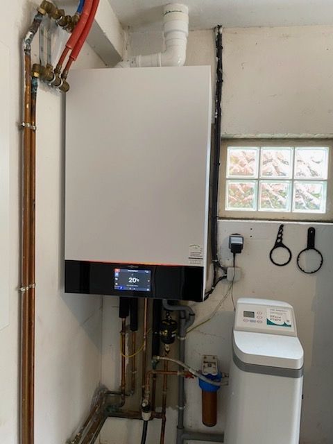 Grand chauffe-eau dans une buanderie indiquant 20°C