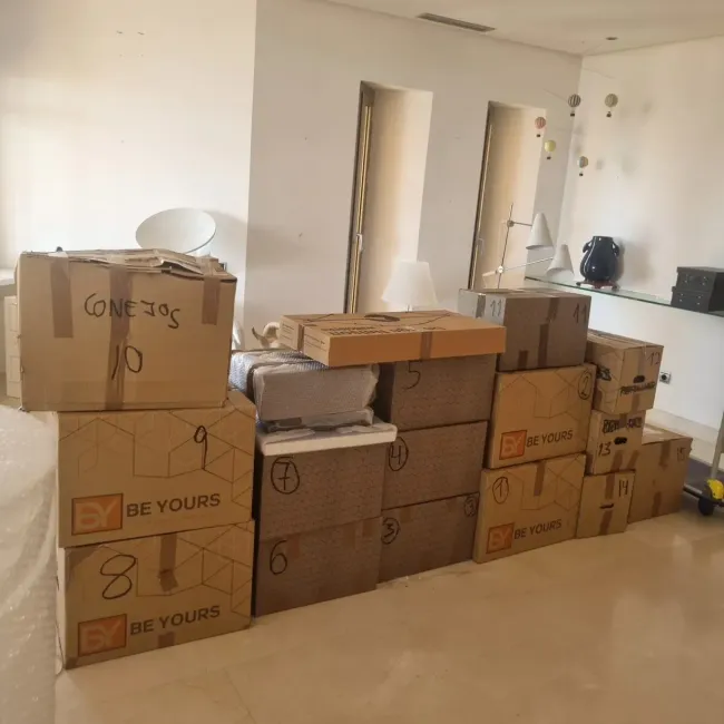 Cajas de cartón apiladas en una habitación, numeradas para su mudanza.