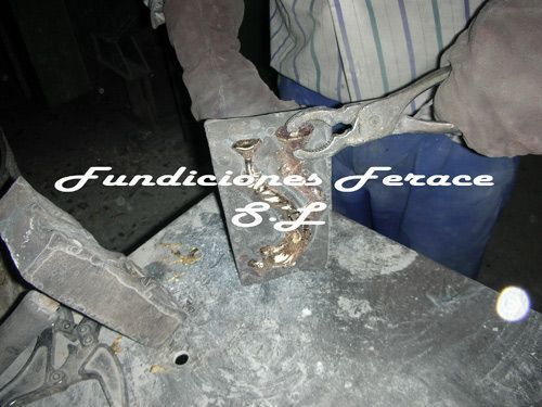 Un hombre está trabajando en una pieza de metal que dice fundiciones ferace