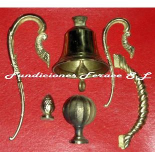 Una campana de bronce reposa sobre una superficie roja con las palabras fundiciones ferace sl debajo.