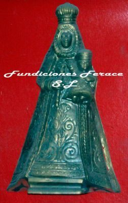 Una estatua de una mujer sosteniendo a un bebé está sobre un fondo rojo.