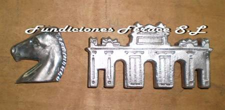 Un emblema de metal con una cabeza de caballo y un castillo.