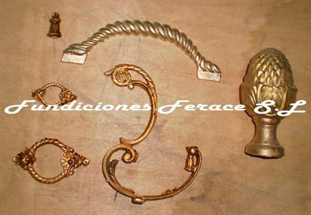 Un montón de piezas de latón sobre una mesa con la inscripción fundiciones ferace sl