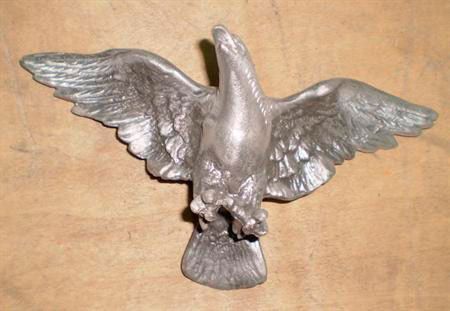 Una estatua de un águila con sus alas abiertas está sentada sobre una mesa.