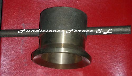 Un objeto de metal está sobre una superficie roja con la palabra fundación escrita en él.