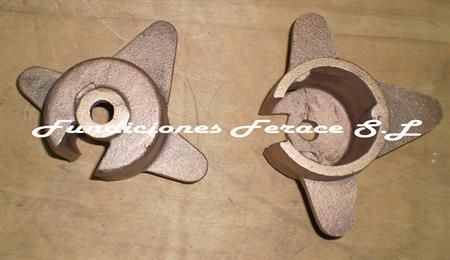 Dos piezas de metal están una al lado de la otra sobre una mesa.