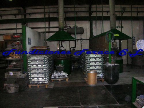 Un almacén con muchos lingotes de aluminio en paletas.