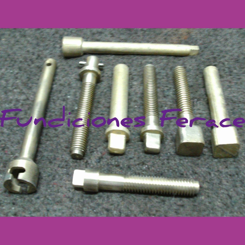 Un montón de diferentes tipos de tornillos están sobre una mesa.