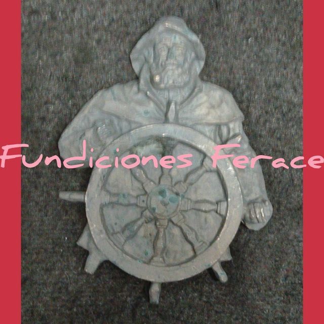 Una estatua de un hombre sosteniendo un volante con las palabras 