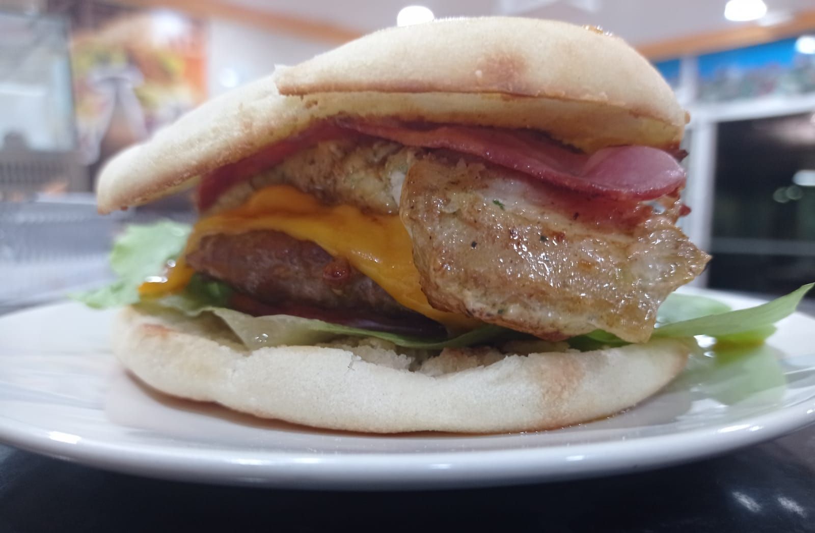 Un primer plano de una hamburguesa en un plato blanco.
