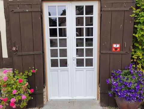 Une porte blanche avec volets en bois