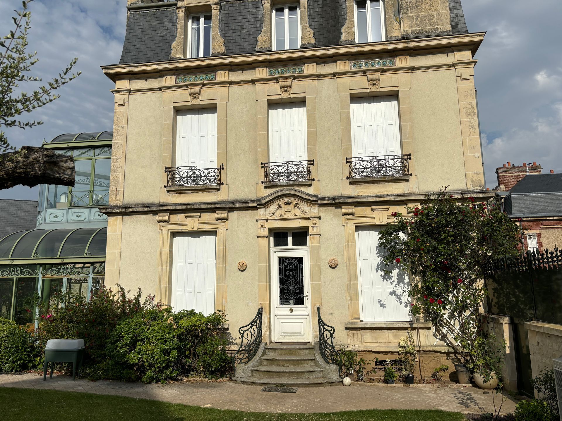 Ancienne maison avec des volets et porte d'entrée blanche