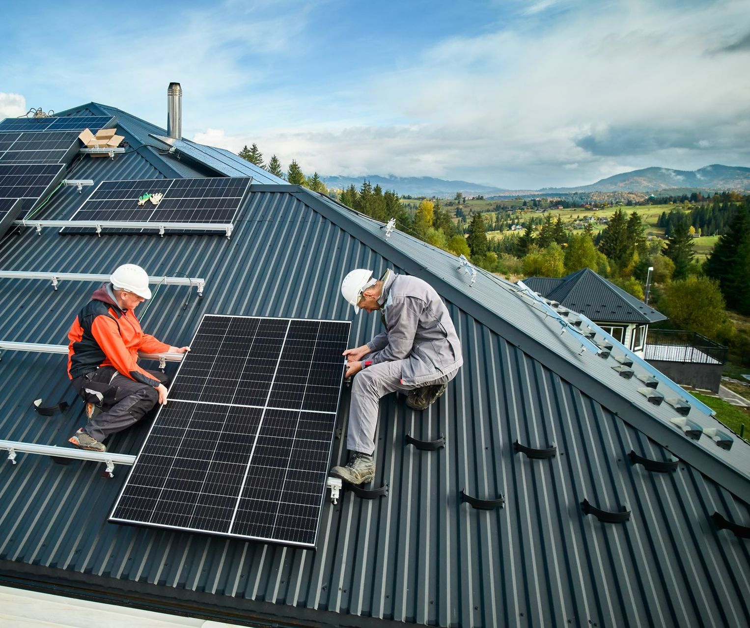 Deux artisans sur un toit en train de réparer un panneau