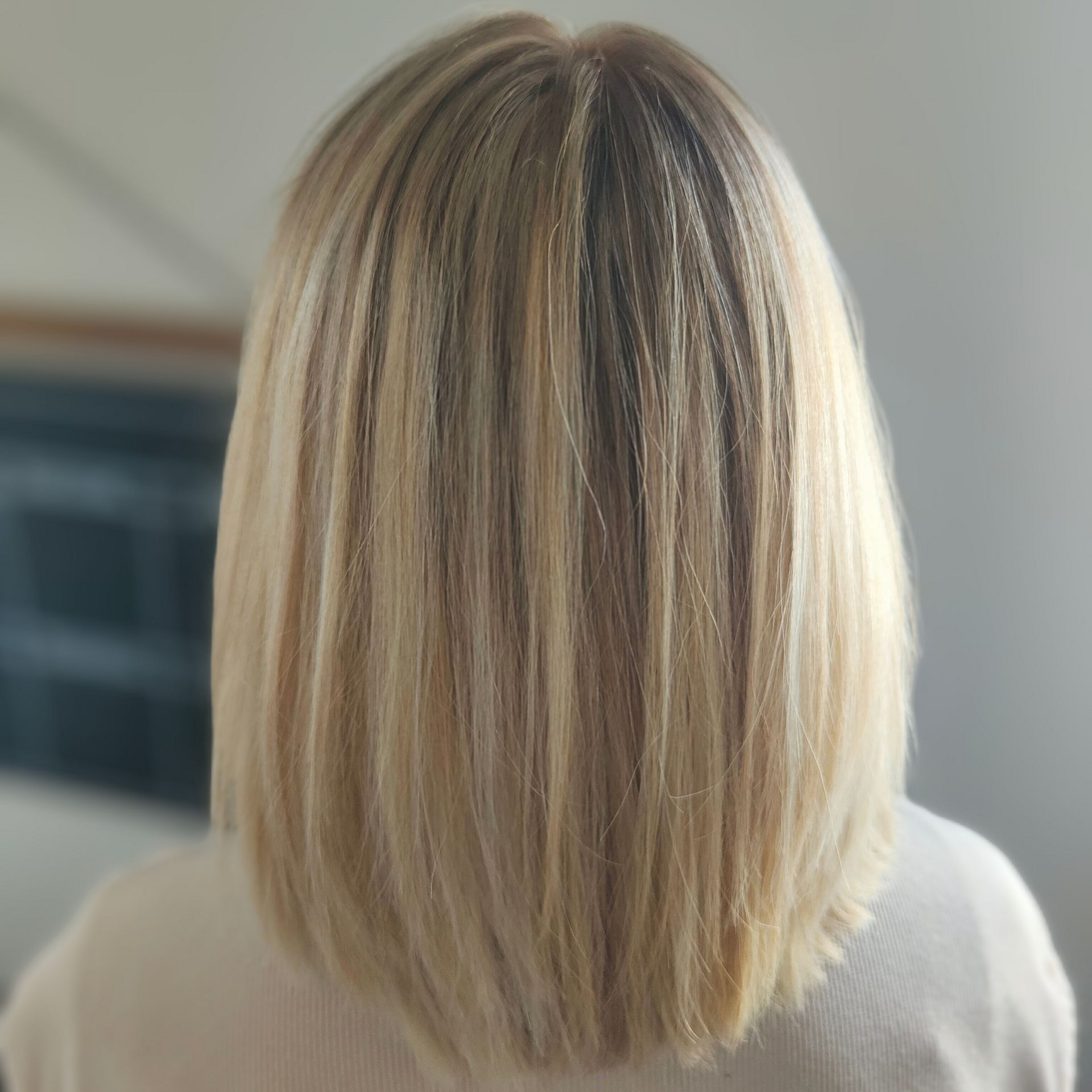 Coiffure bob blonde, vue de dos, avec des mèches de paillettes.
