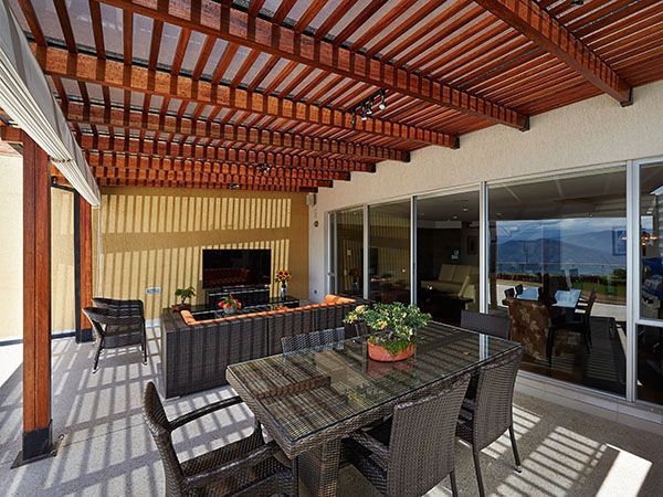 Grande pergola bois au-dessus d'un salon de jardin