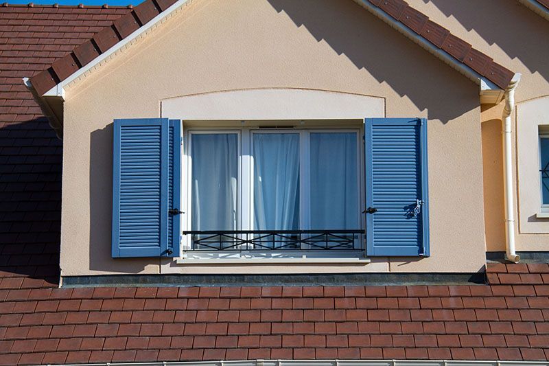 Volets battants bleu pour une fenêtre large
