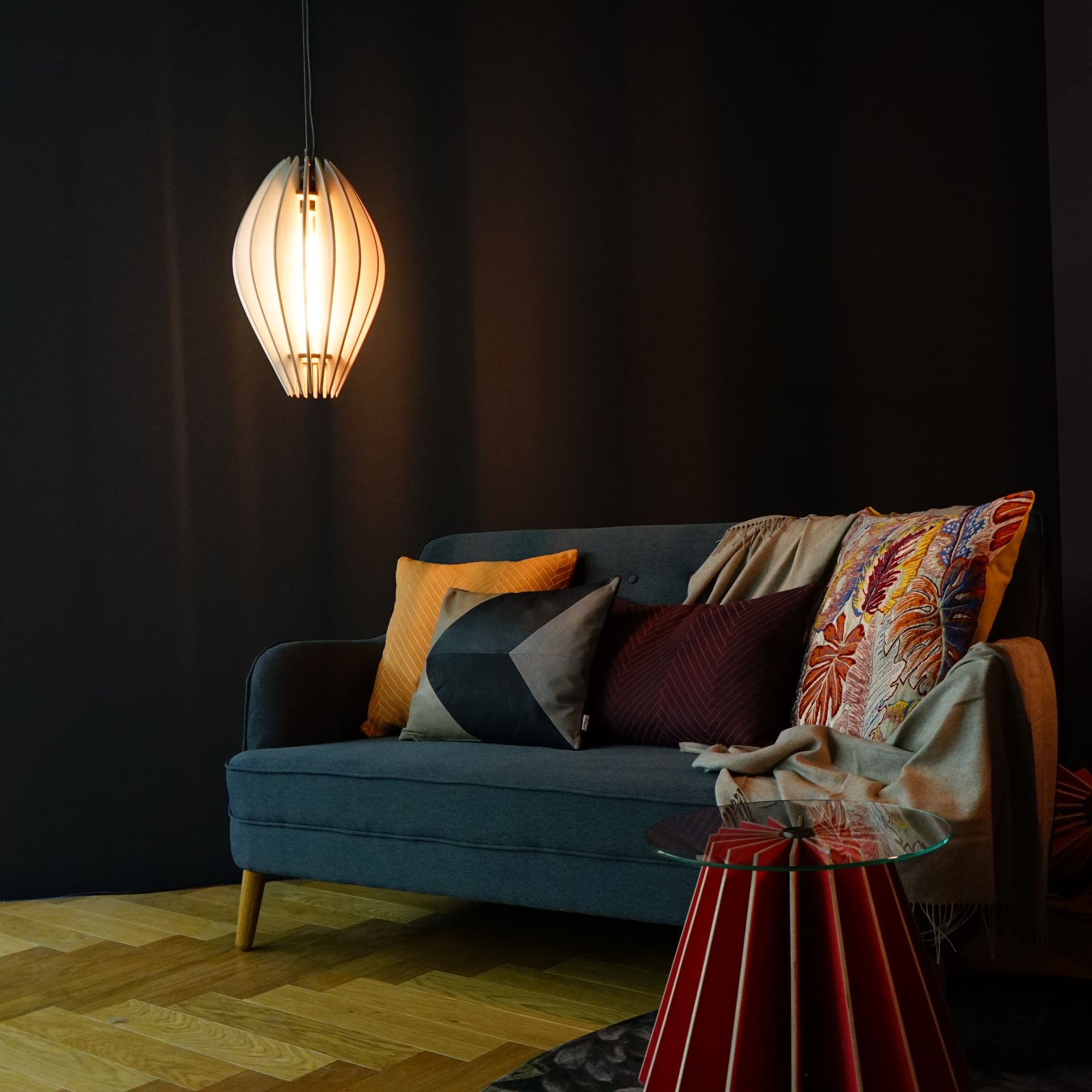 Schwarzer Koffer mit Metallbeschlägen auf Holzsockel.