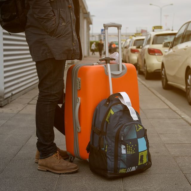 Des taxis alignés à une station de taxis, éclairés par des lampadaires la nuit.