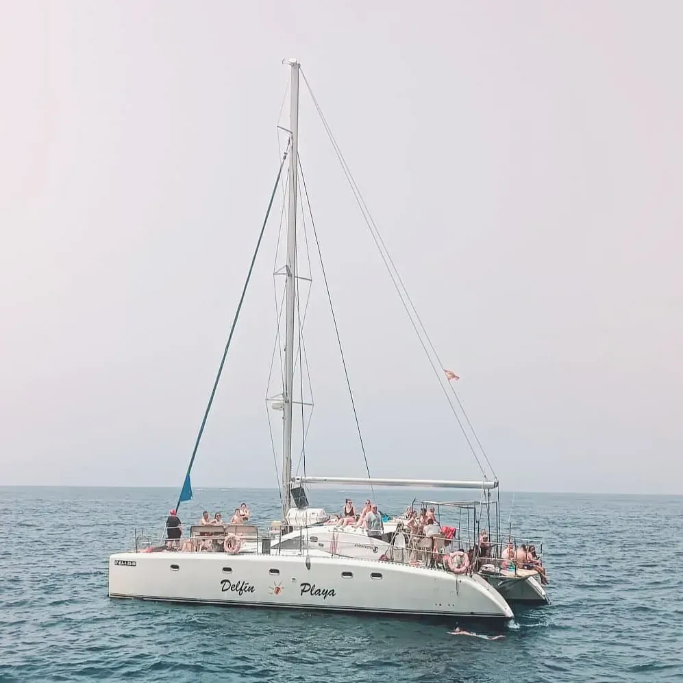 Un grupo de personas está en un velero en el océano.