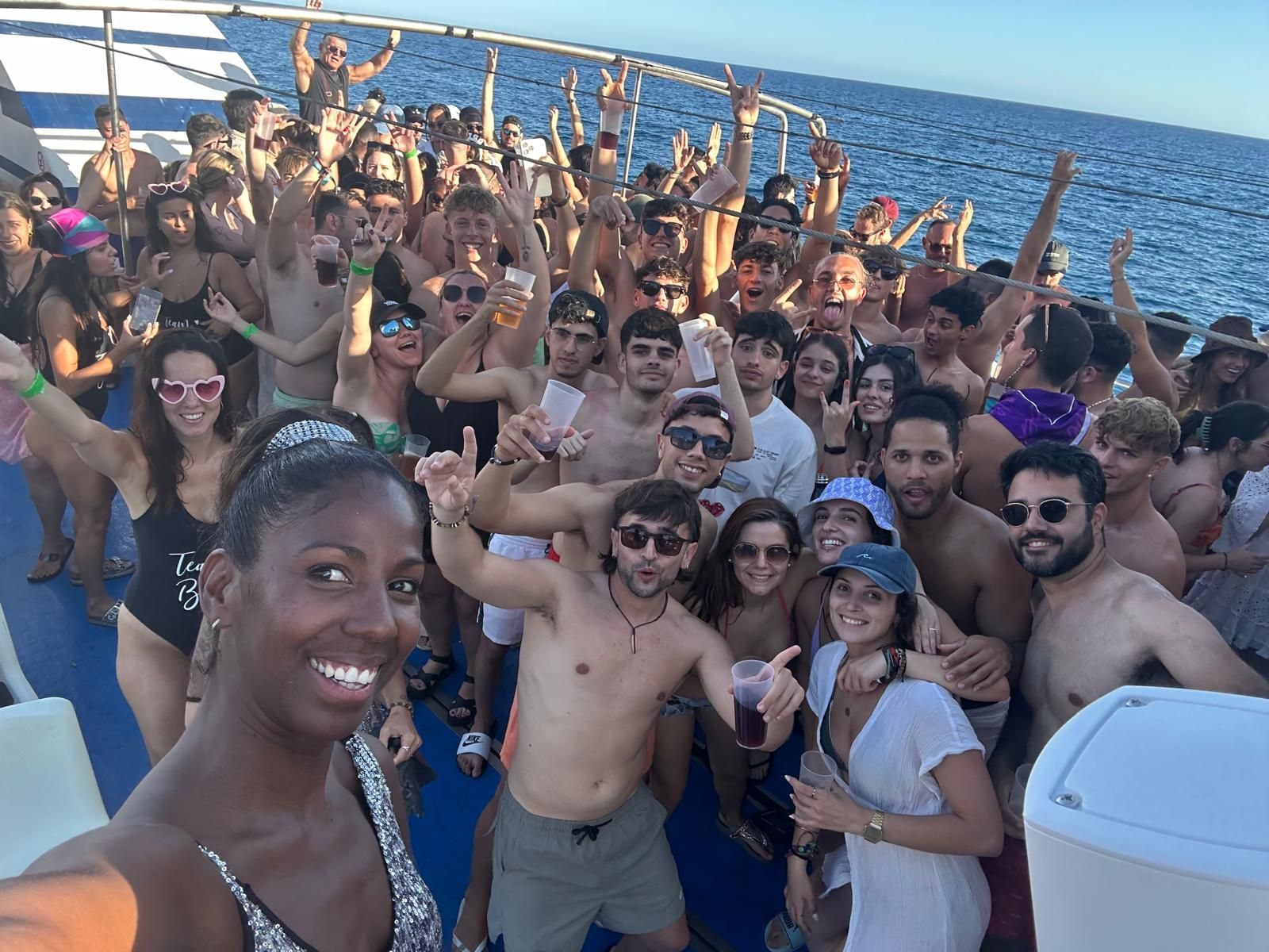 Un grupo de personas posa para una fotografía en un barco en el océano.