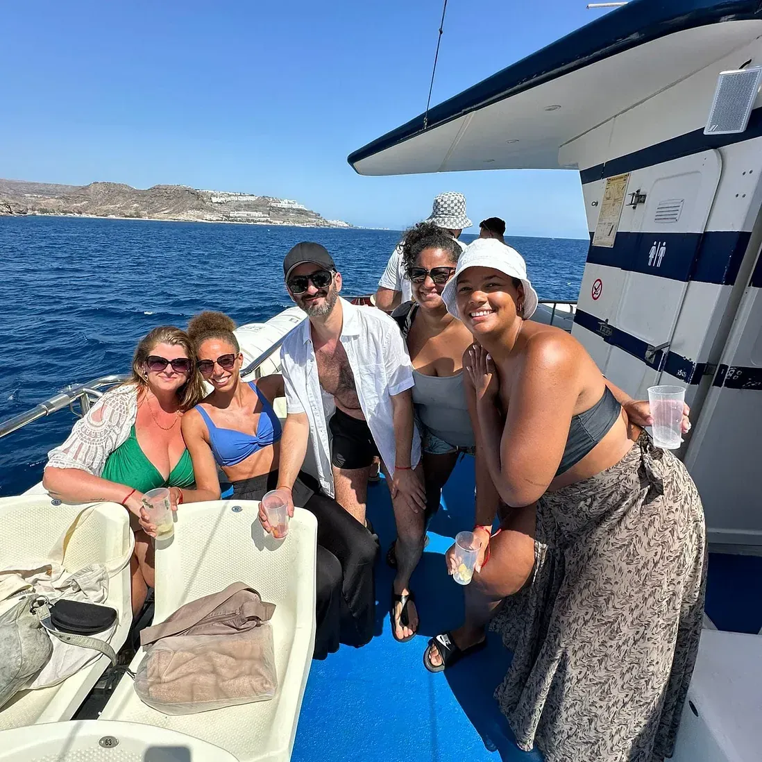 Un grupo de personas posa para una fotografía en un barco en el océano.