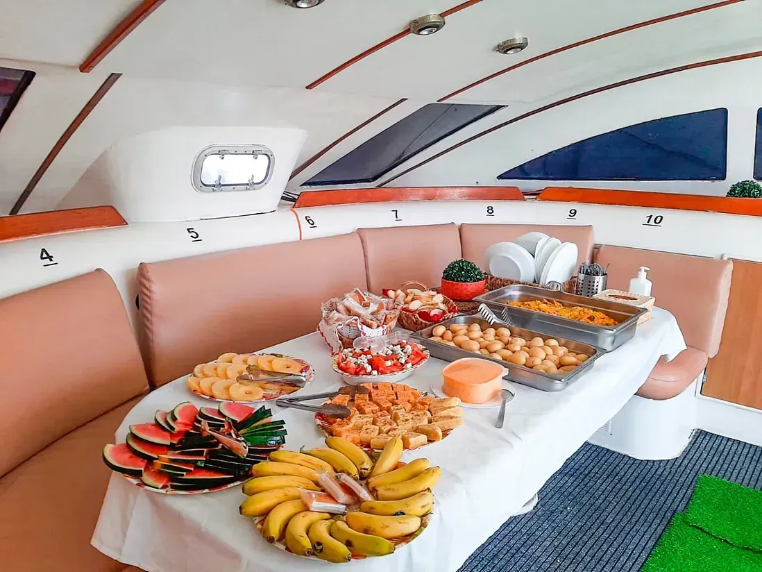 Hay una mesa con mucha comida en un barco.