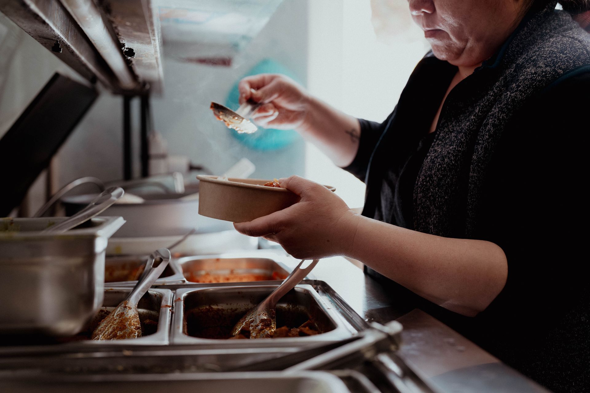 Frau und Kind wählen Obst und Gemüse in der Kühltheke eines Supermarkts aus.