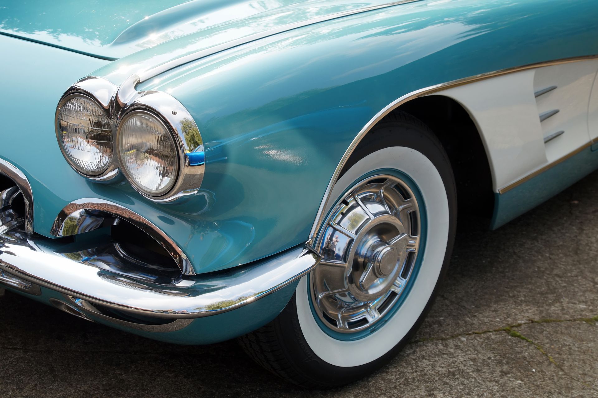 Türkis-weißer Oldtimer mit Chromakzenten und Weißwandreifen.