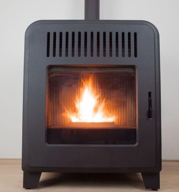 Schwarzer Kompaktofen mit sichtbarer Flamme hinter einer Glastür, im Innenbereich auf einem Holzboden