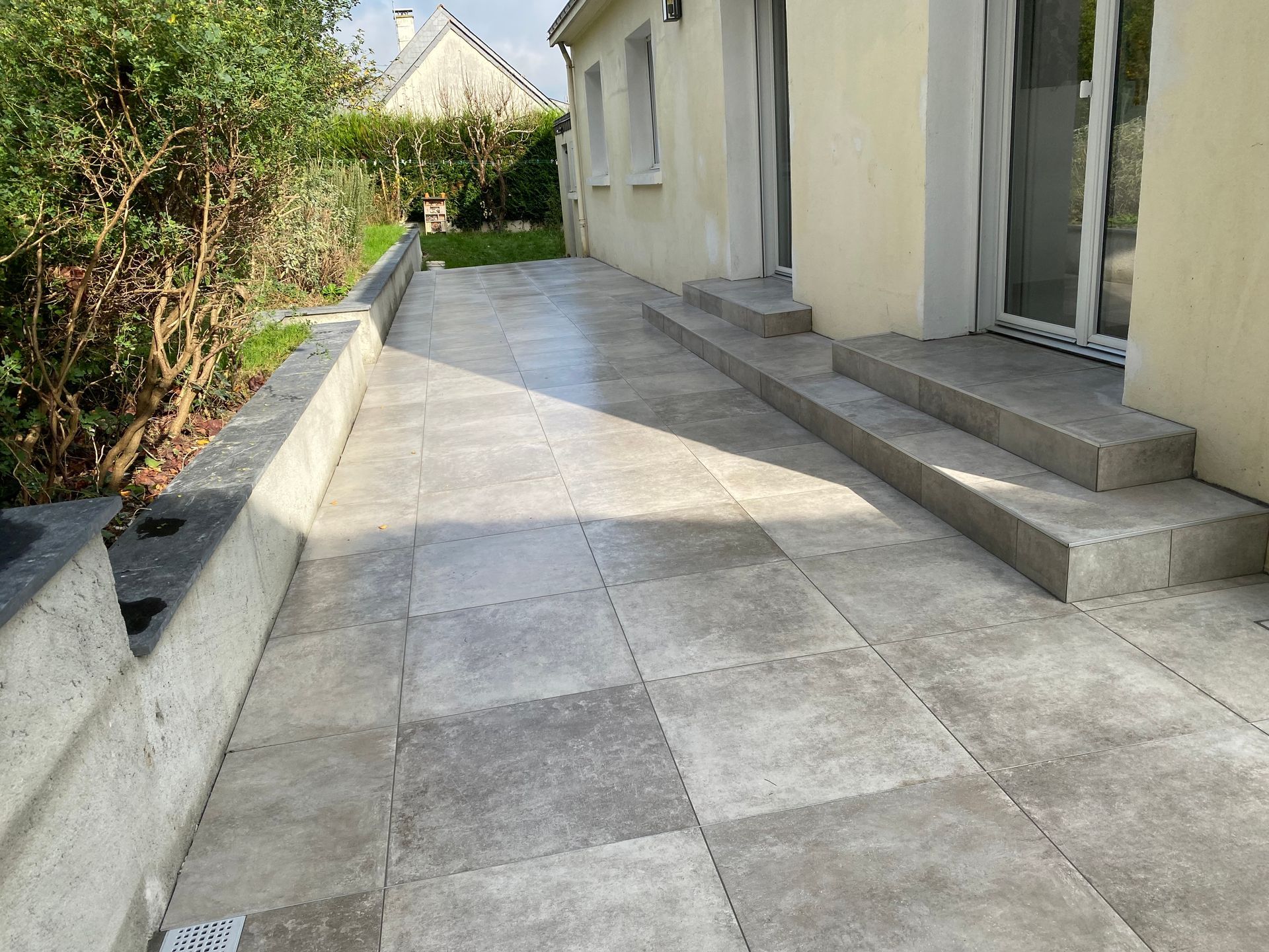 Dallage carreaux tons gris à l'extérieur d'une maison