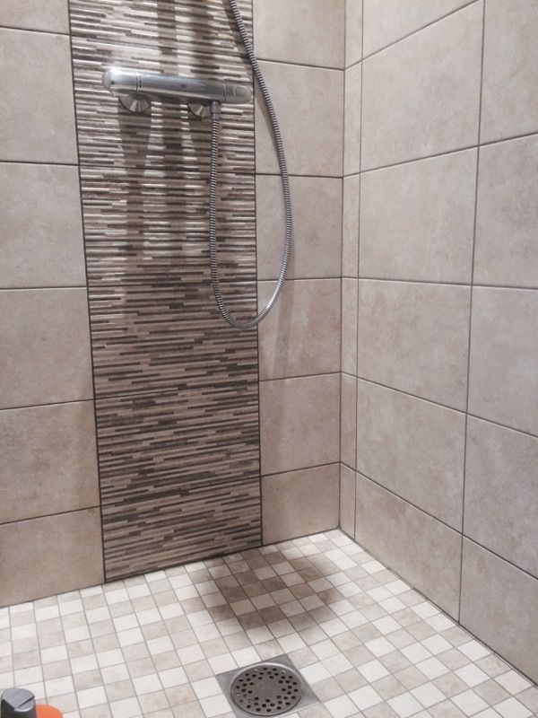 Douche avec murs et sol en carrelage gris