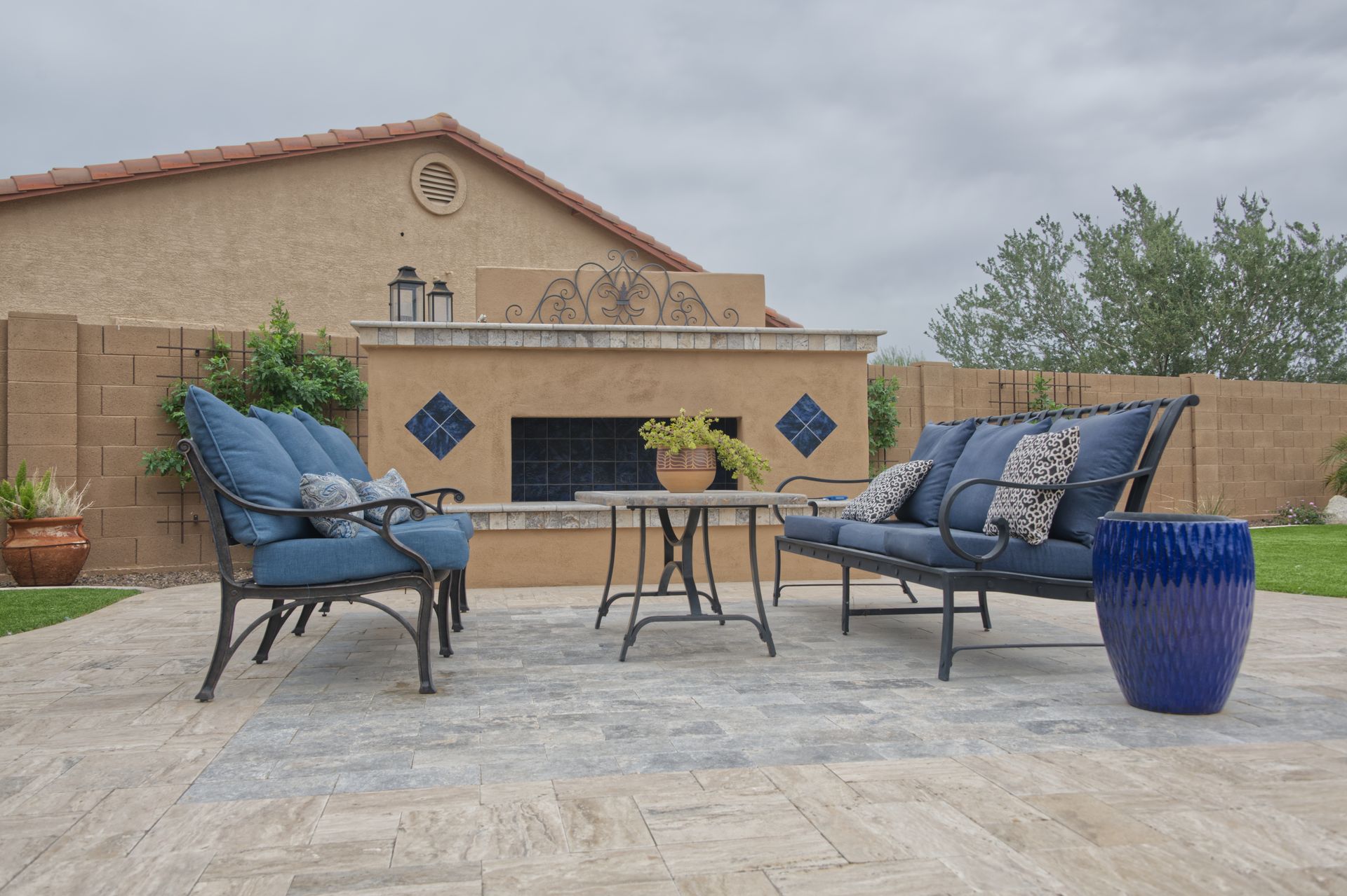 Terrasse extérieure avec mobilier bleu sur un sol en travertin