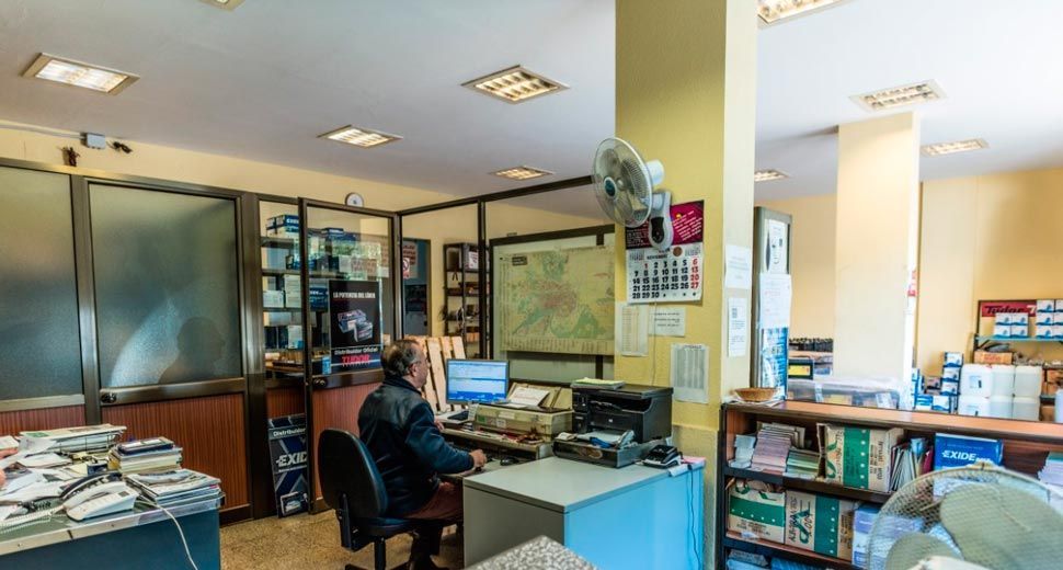 Un hombre está sentado en un escritorio en una oficina trabajando en una computadora.