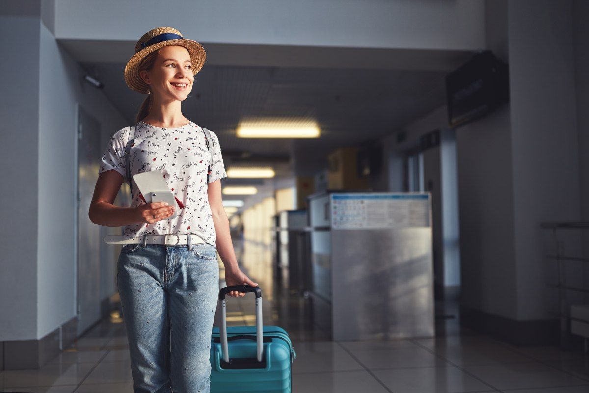 Jeune femme dans un aéroport avec sa valise