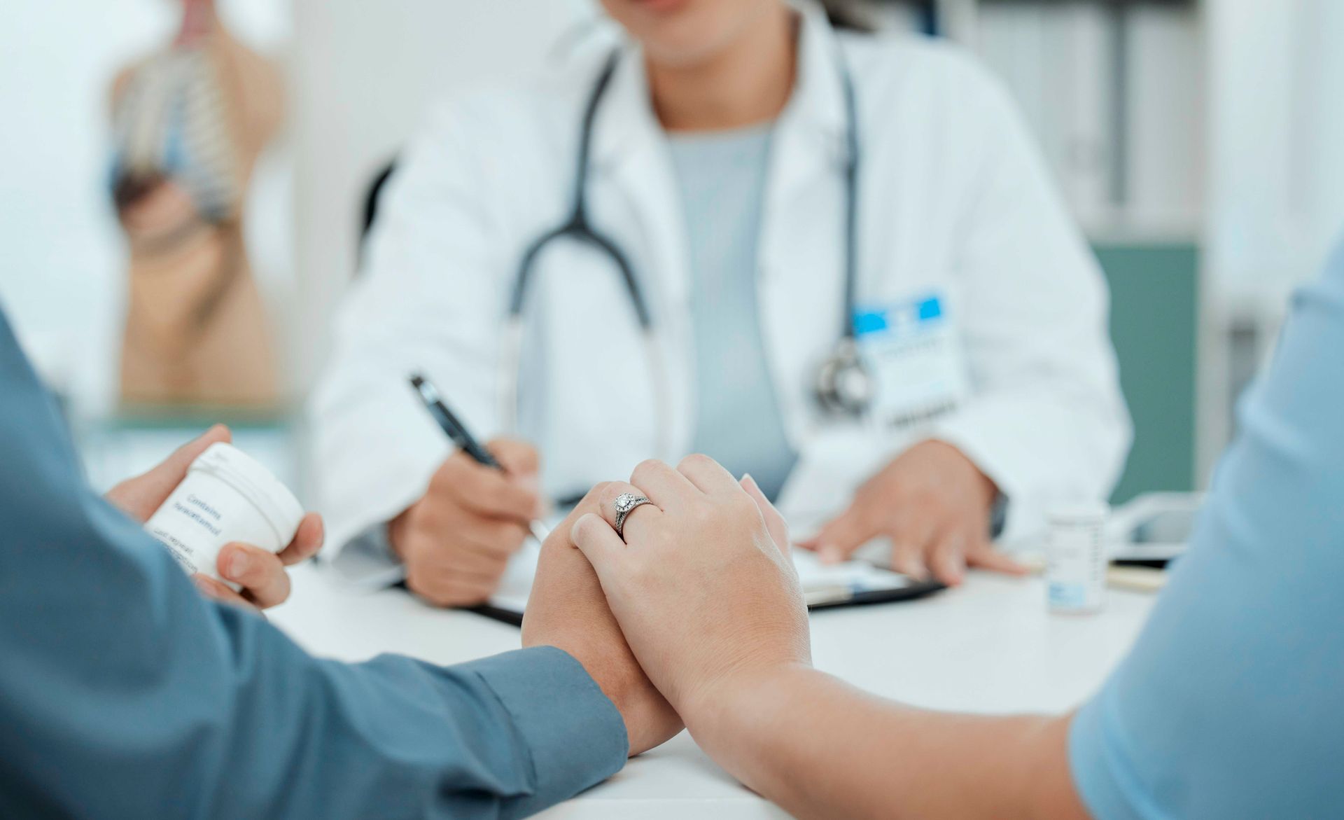 Der Arzt spricht mit dem Patienten an seinem Schreibtisch in der hellen Klinik