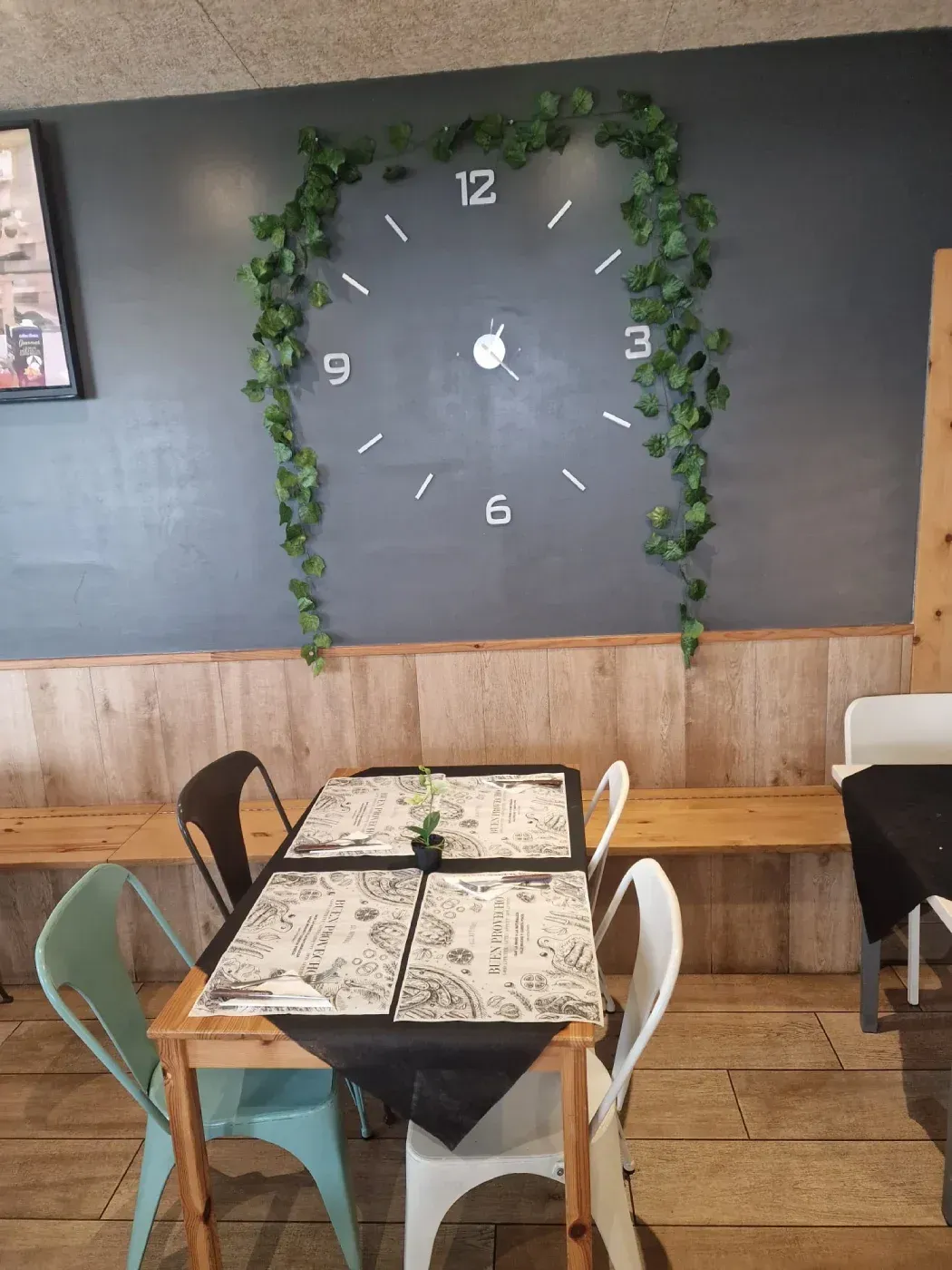 Un restaurante con un gran reloj en la pared encima de la mesa.